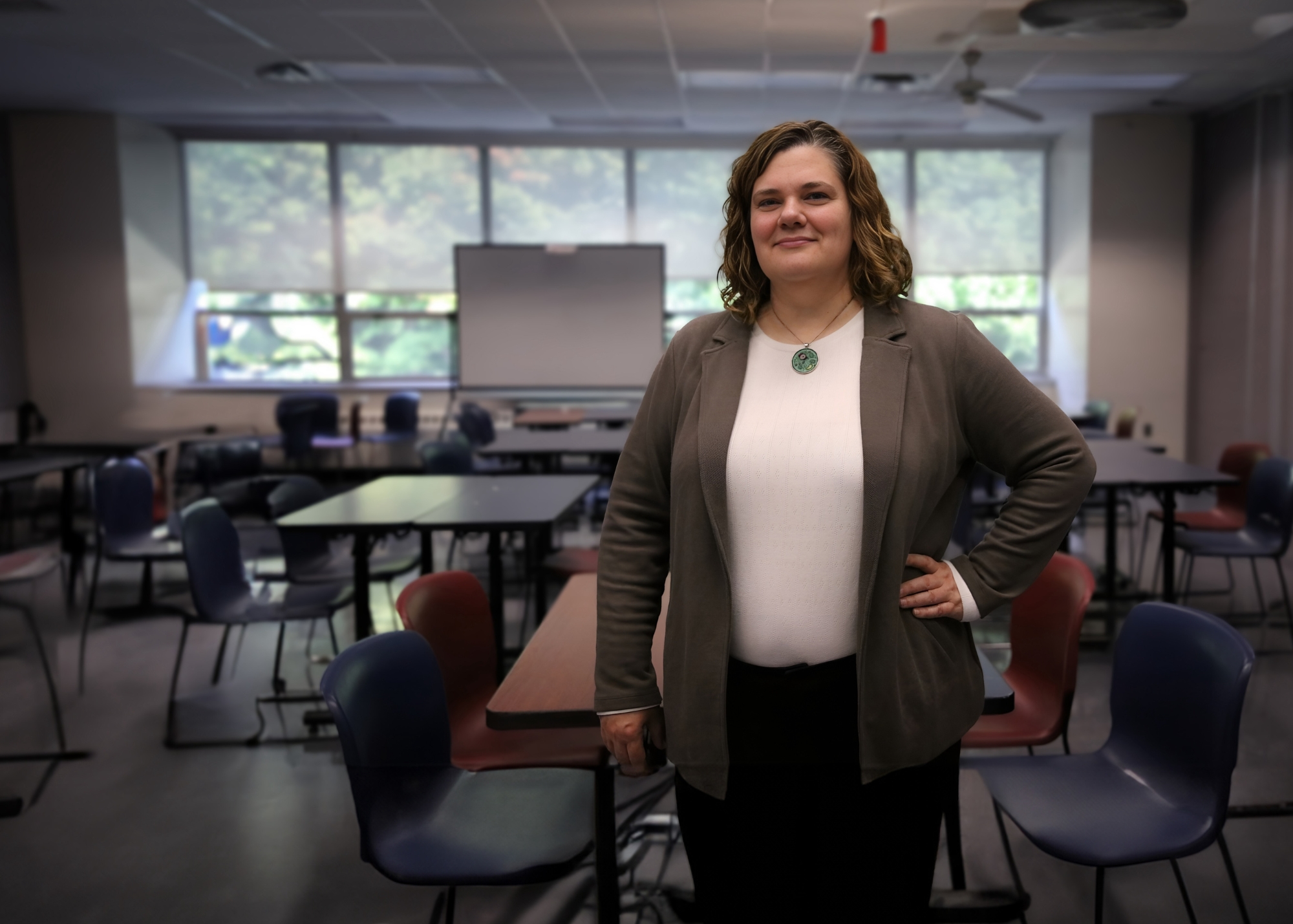 Jennifer Doherty poses in front of an empty classroom.