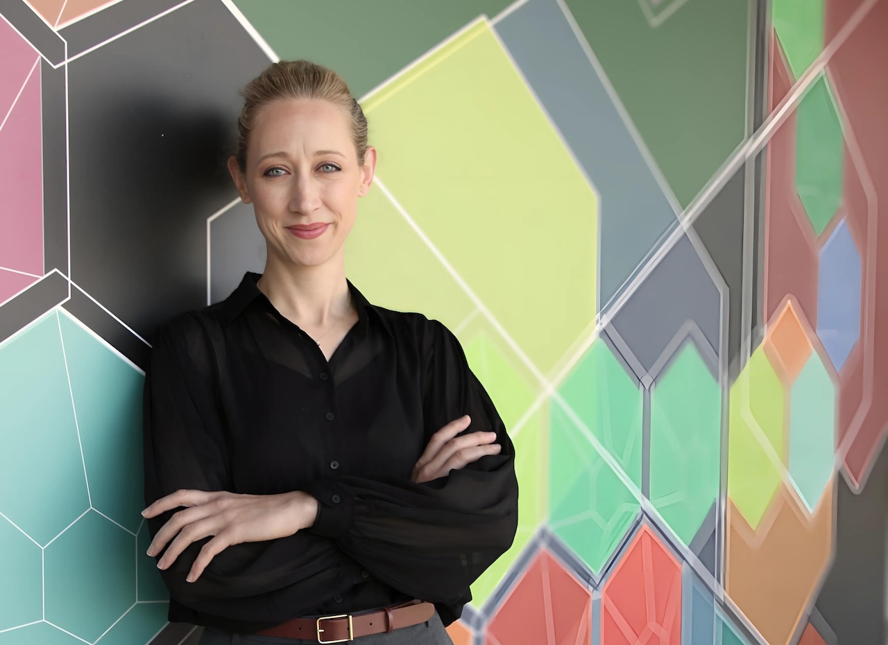 Picture of Sarah Elzinga leaning against a multi-colored wall.