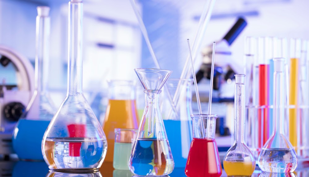 scientific looking beakers in a brightly lit room